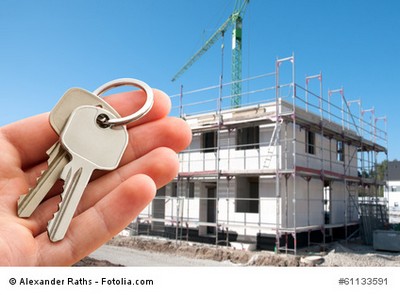 Rohbau mit Schlüssel in der Hand